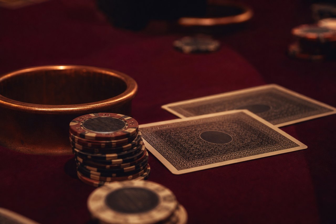 Cartas y fichas de blackjack sobre tapete granate